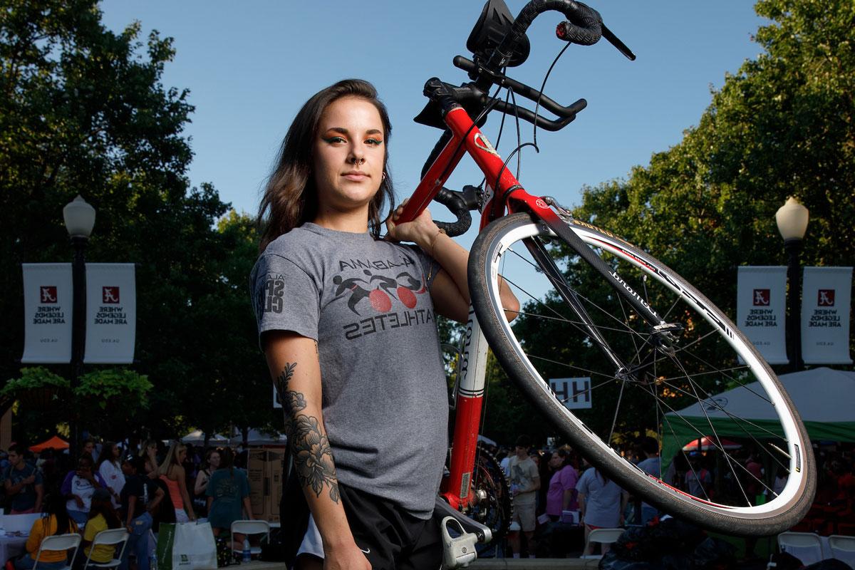 a student holds her bicycle at get on board day